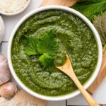Shiso pesto served in a white bowl with a spoon dipped in.