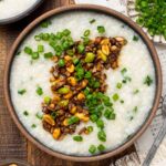 A bowl of vegan congee with toppings.