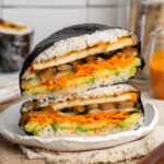Vegan onigirazu sushi sandwich on a white plate.