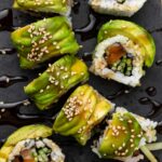 Veggie caterpillar roll served on a black board.